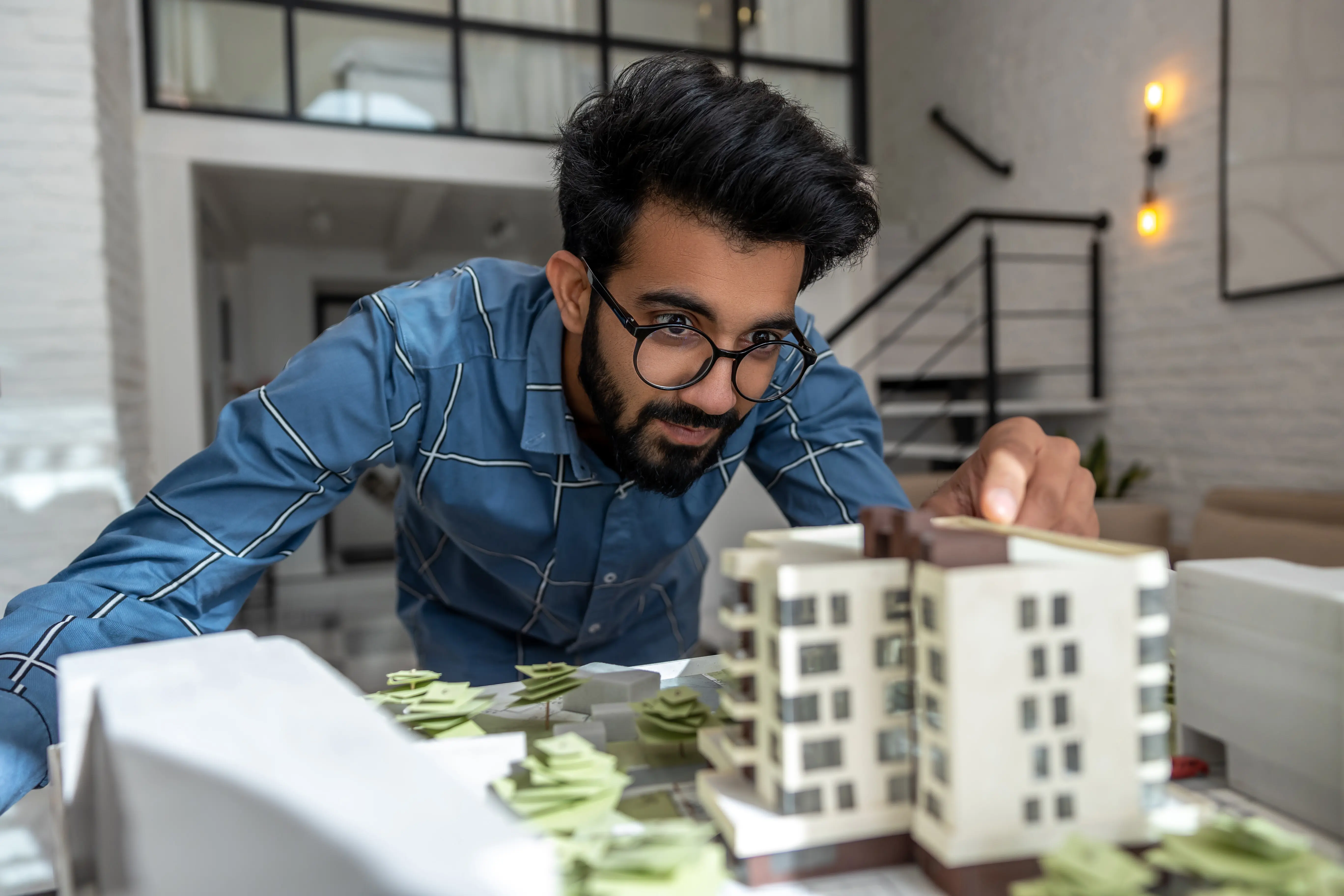 A young engineer looks busy and engaged while preparing a house mock-up.