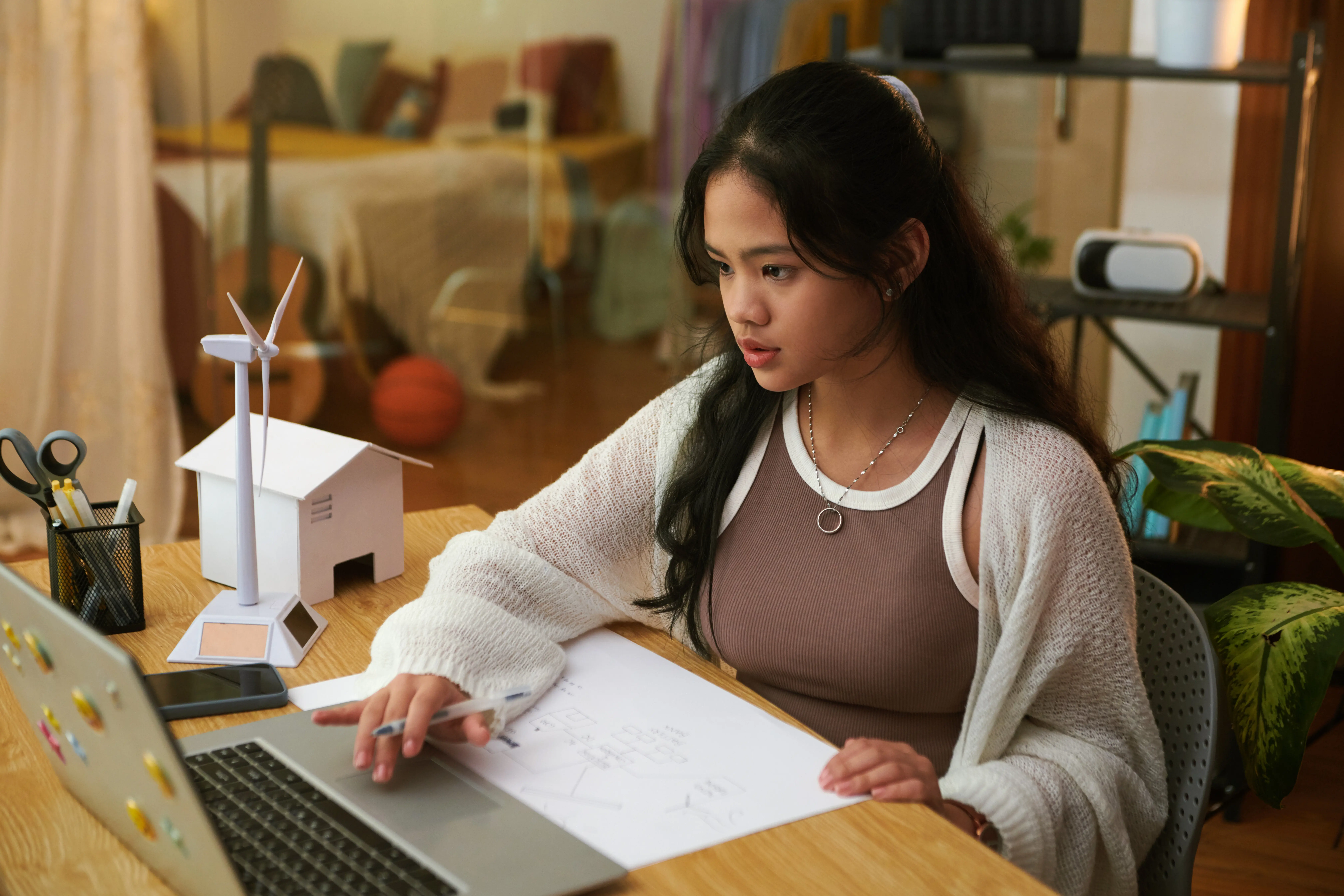 A schoolgirl studying at home, learning about green energy sources.